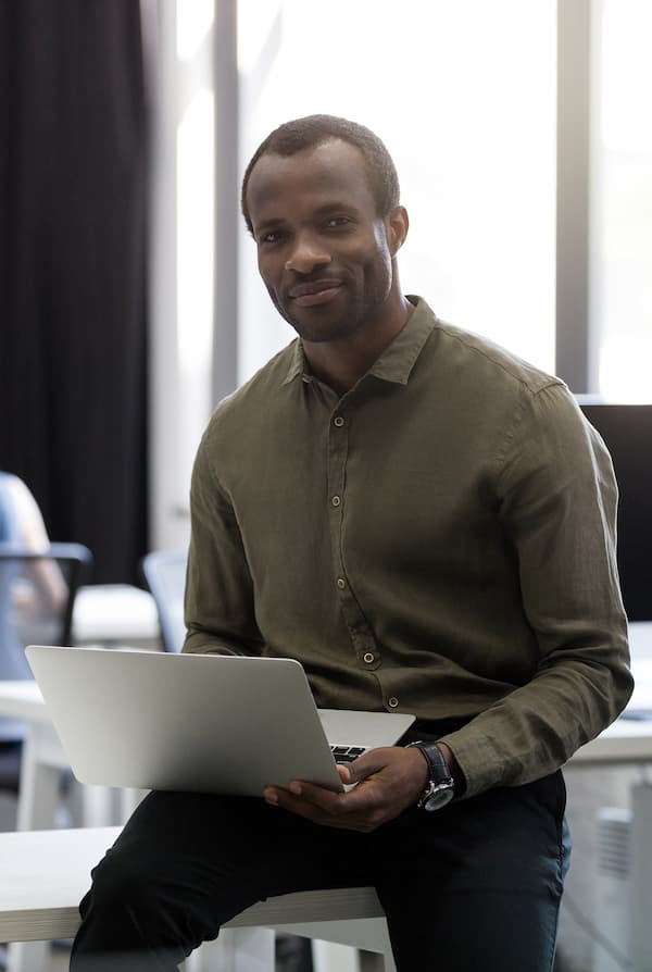 Man holding laptop looking forward