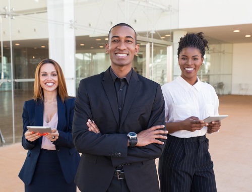 a man and 2 women standing and smiling